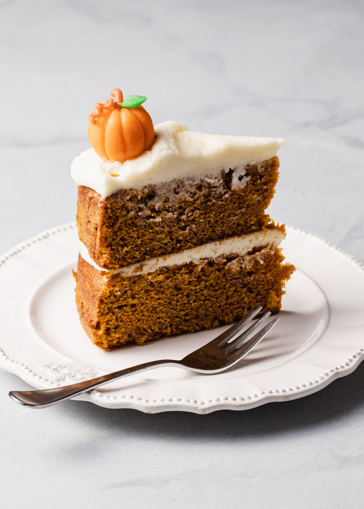 A slice of maple pumpkin cake with cream cream frosting