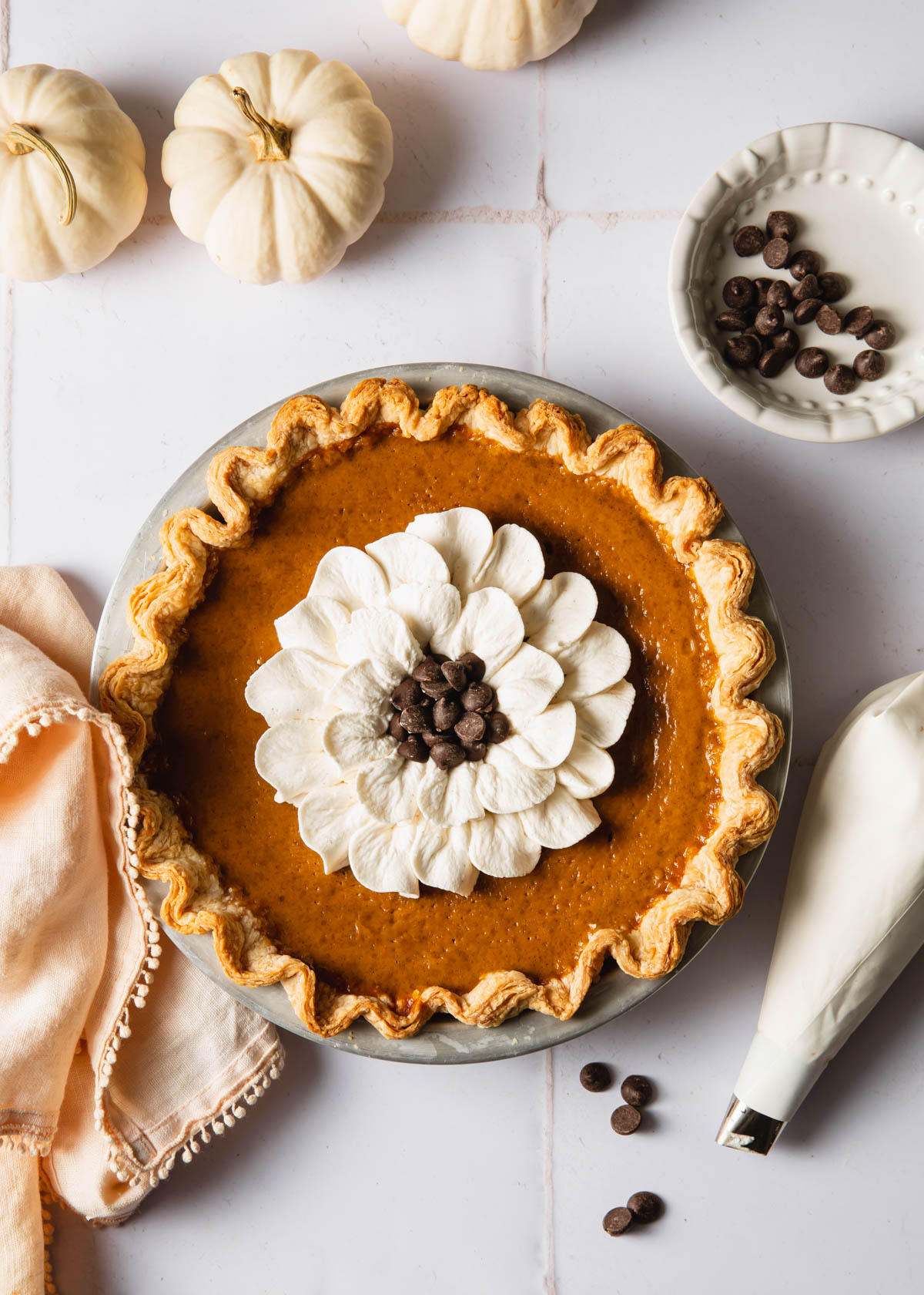 A baked pumpkin pie with whipped cream on top