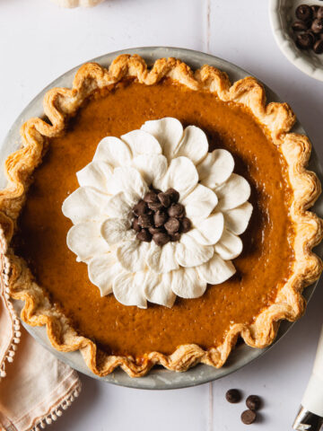 A pumpkin pie with whipped cream on top