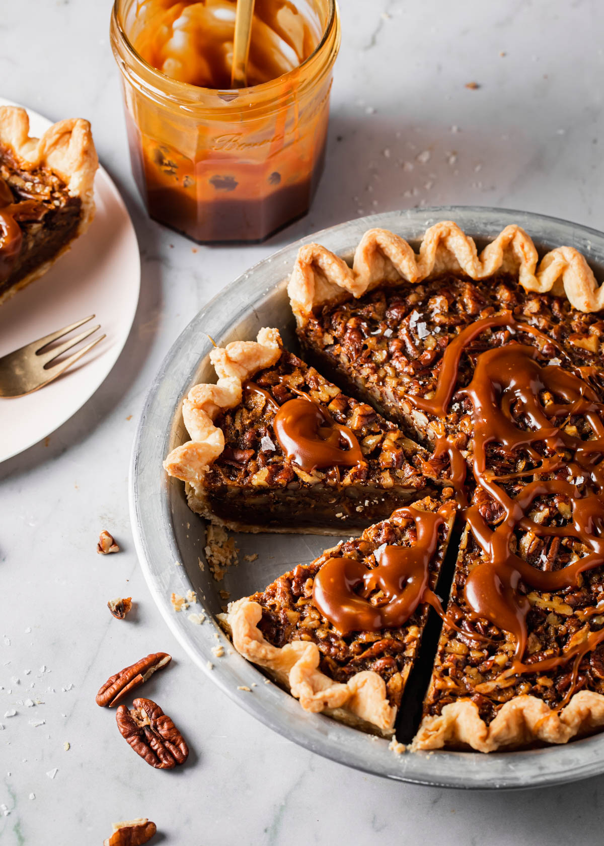 A baked pecan pie with caramel sauce on top