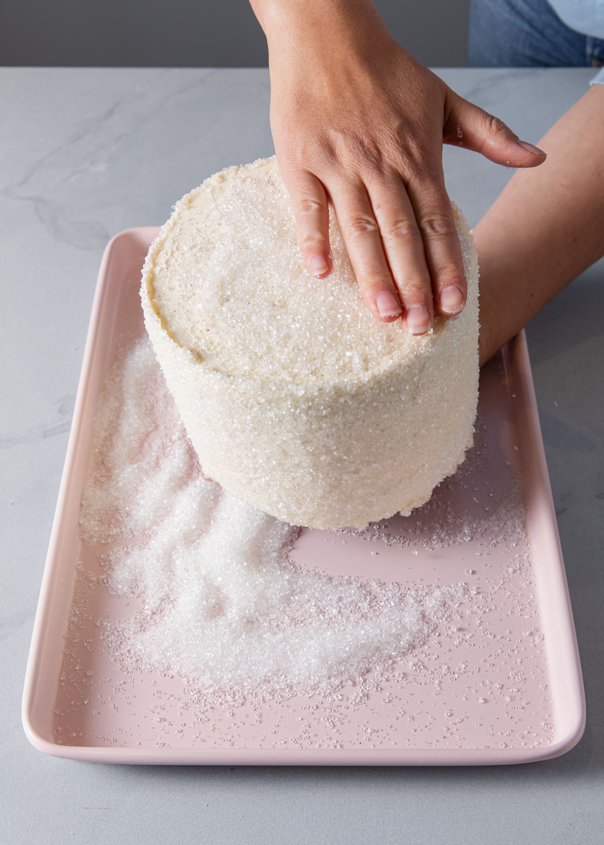 Adding sprinkles to the outside of a cake