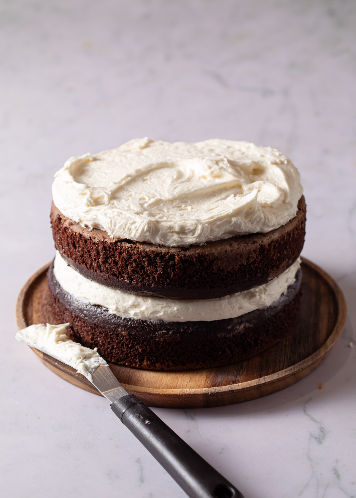 Spreading peppermint buttercream on top of chocolate cake layers