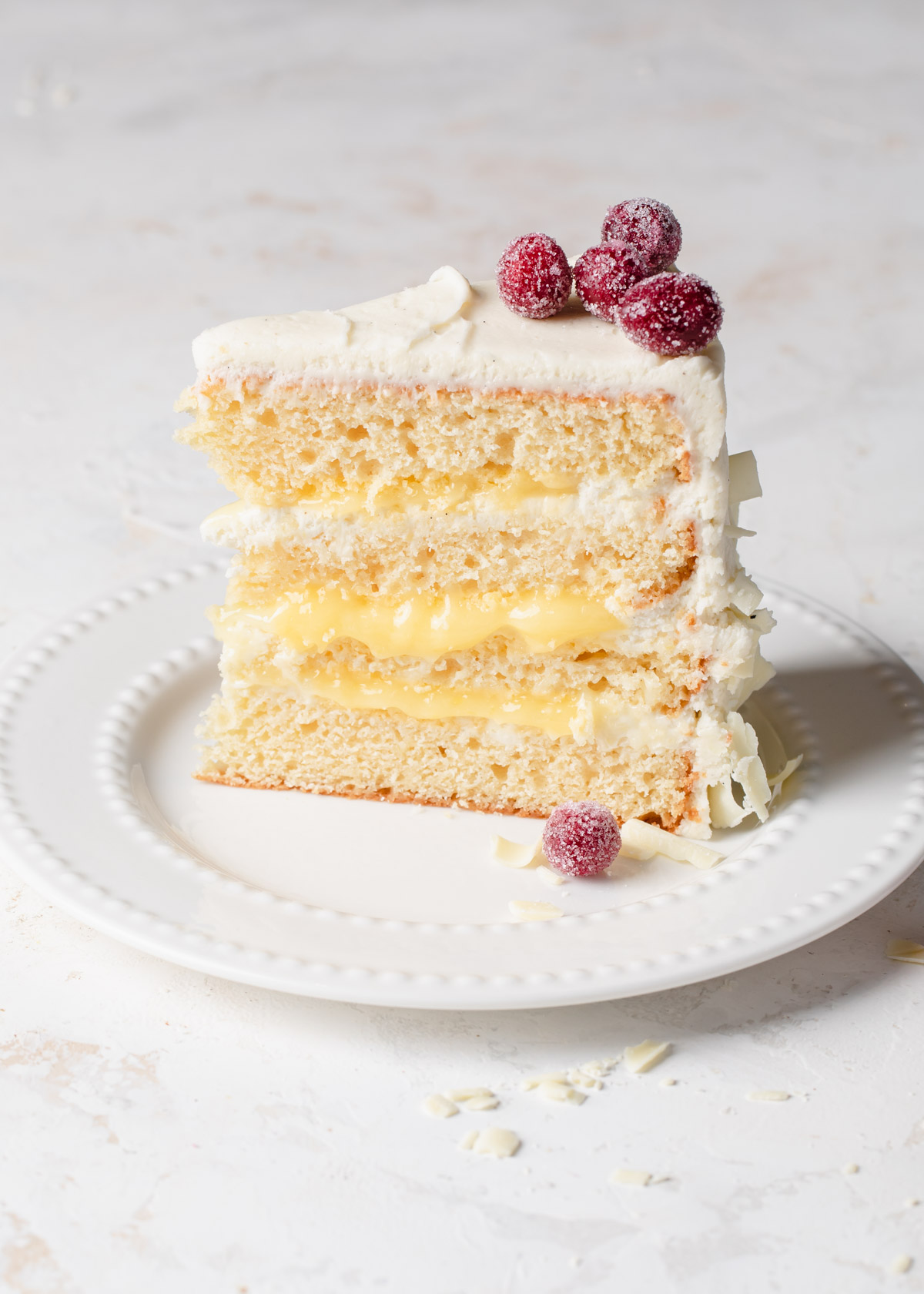 a slice of 4-layer lemon curd cake on a plate