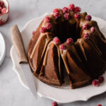 A gingerbread bundt cake with butterscotch glaze on top and sugared cranberries