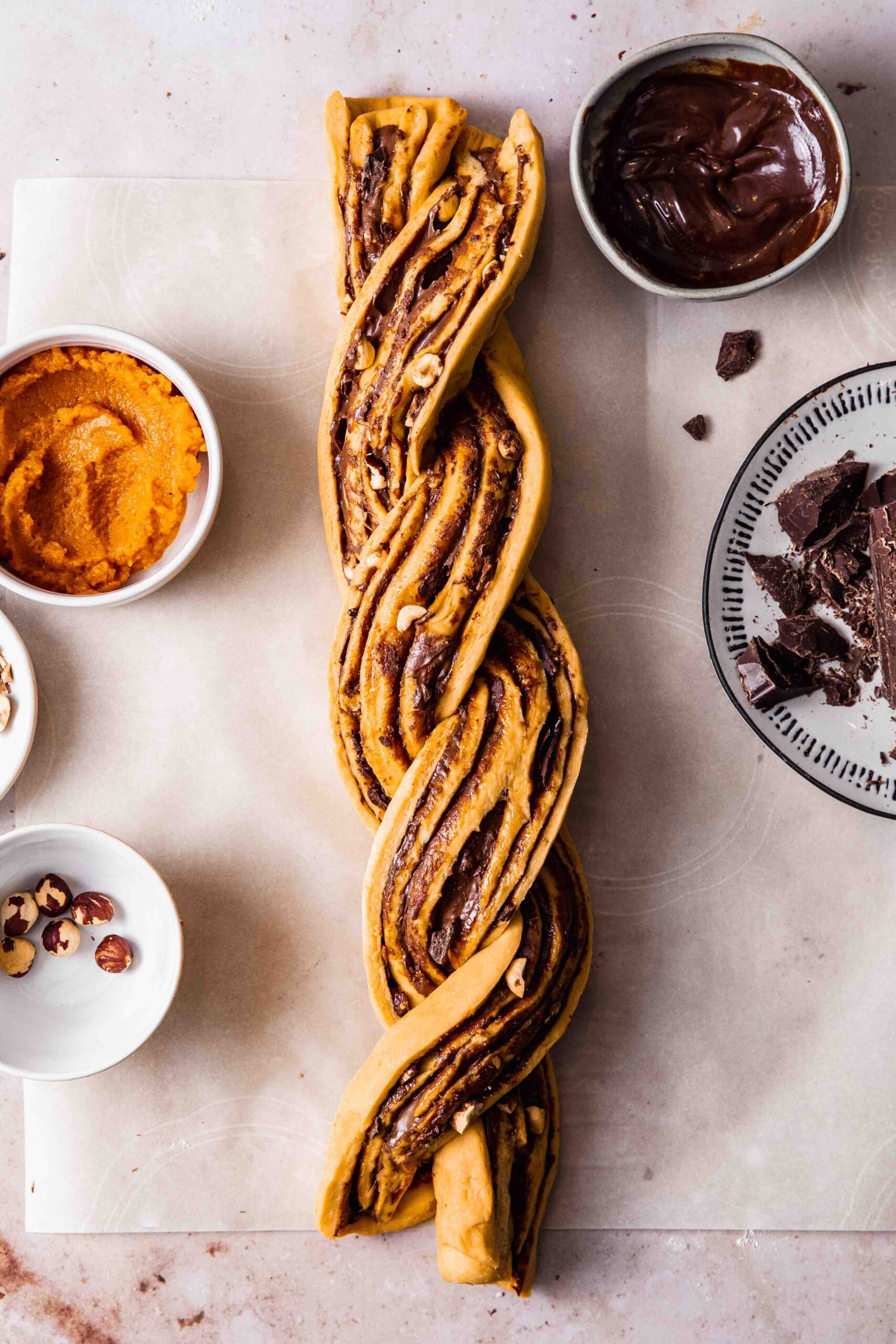 Braiding babka dough filling with chocolate spread before baking.