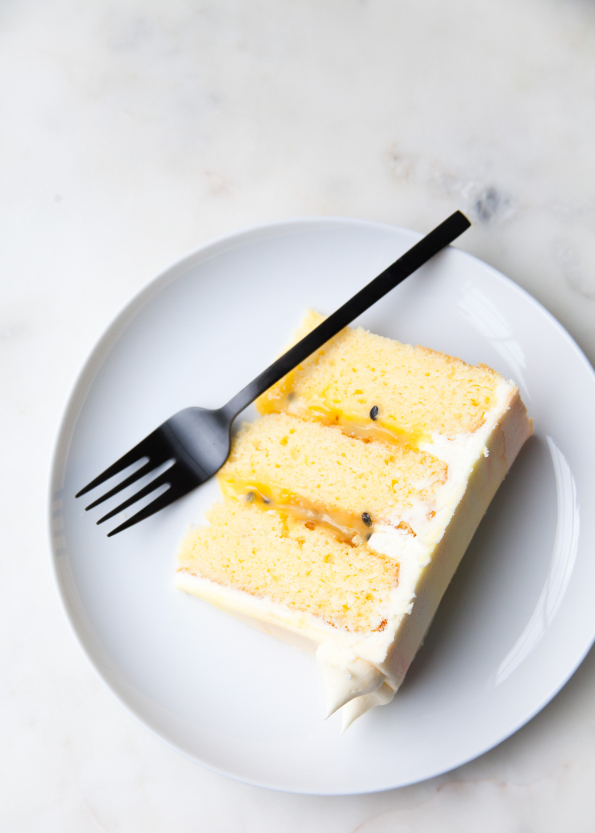 A slice of 3-layer passion fruit cake on a plate