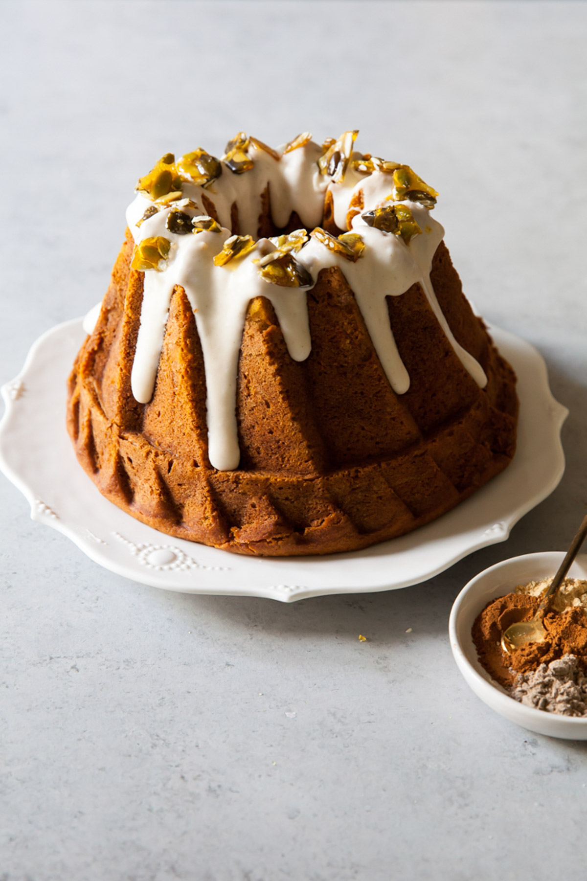 a chai spiced pumpkin bundt cake with cream cheese glaze a pumpkin seed brittle