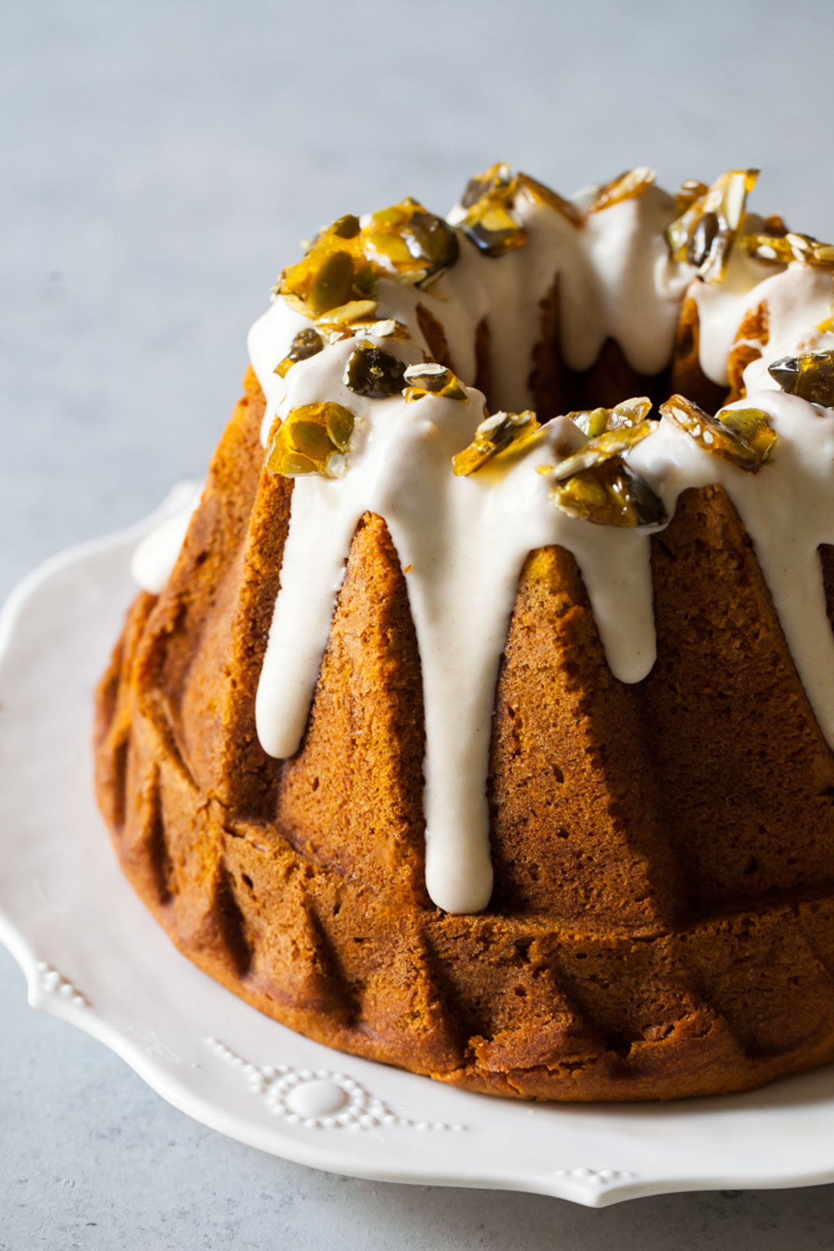 A close-up of cream cheese glaze on a pumpkin bundt cake