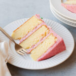 A slice of three-layer almond cake with raspberry buttercream