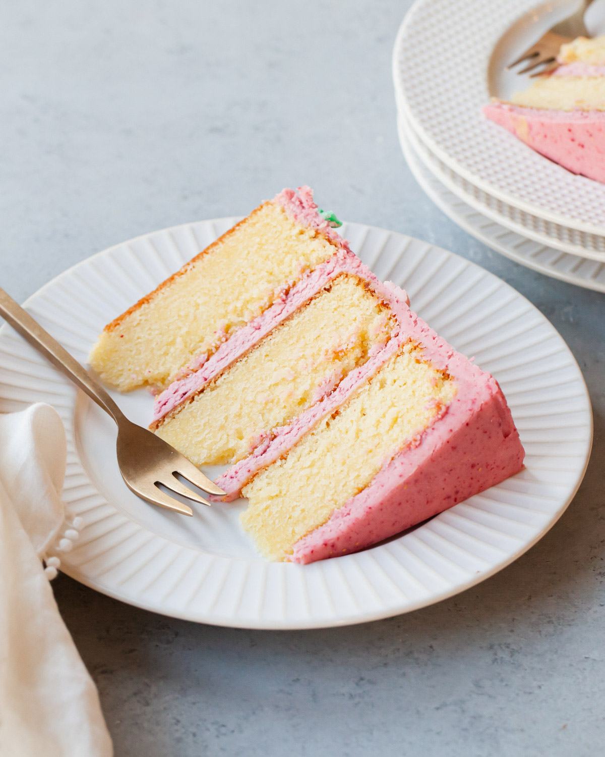 A fluffy, moist slice of almond cake with raspberry buttercream