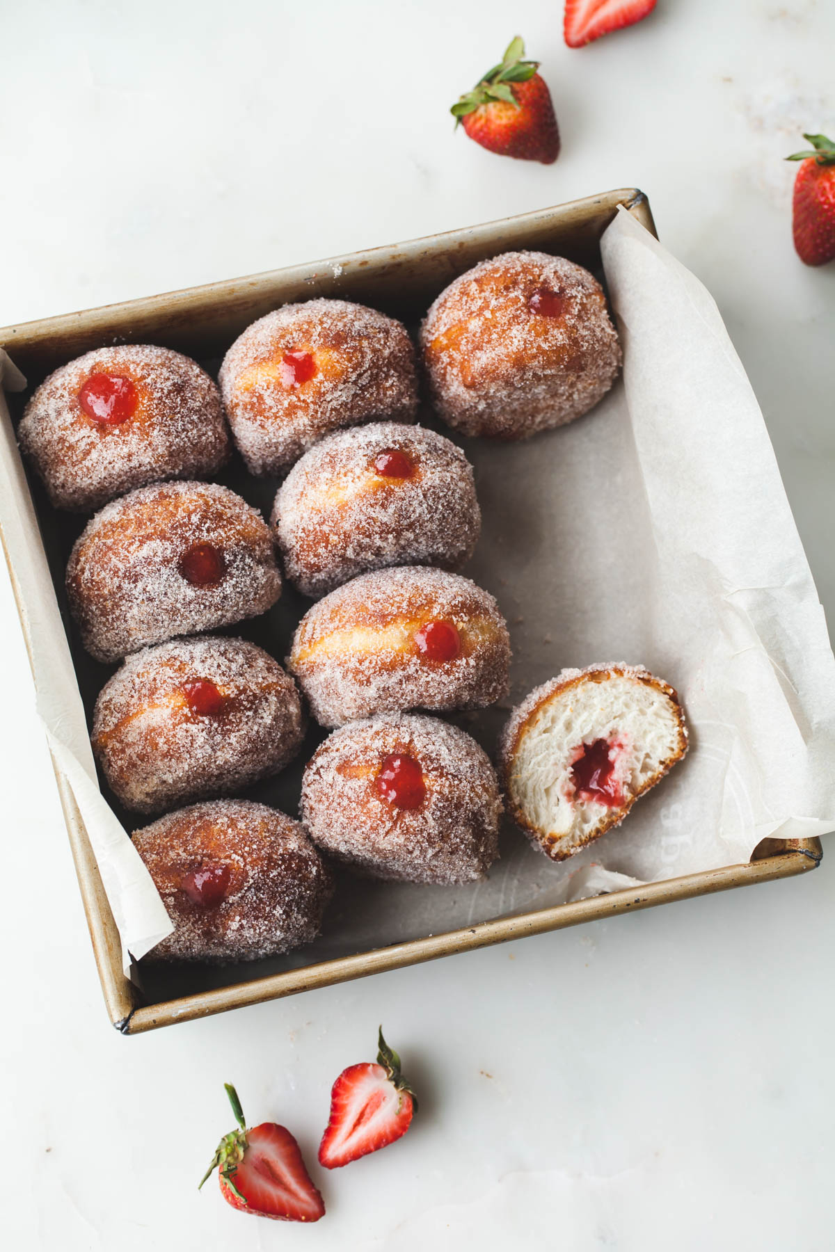 A tray of cinnamon-sugar coated donuts with strawberry rhubarb jelly filling