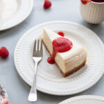 A slice of vanilla cheesecake with raspberry rhubarb sauce on top