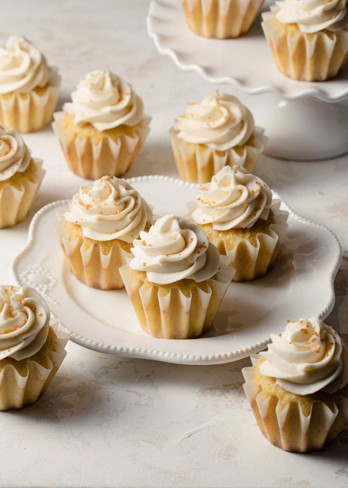 A platter of brown butter cupcakes with swirls of vanilla icing on top