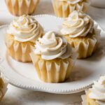 A plate of brown butter cupcakes with swirls of whipped buttercream on top