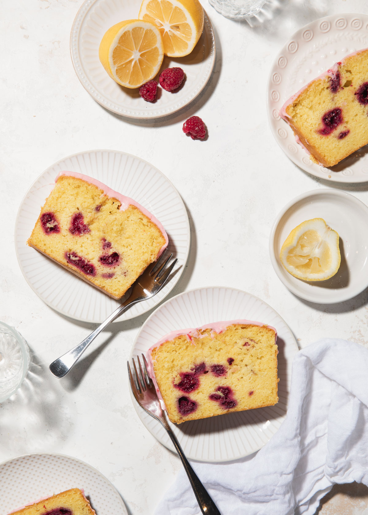 A high-contrast overhead shot of slices of snack cake studded with raspberries.