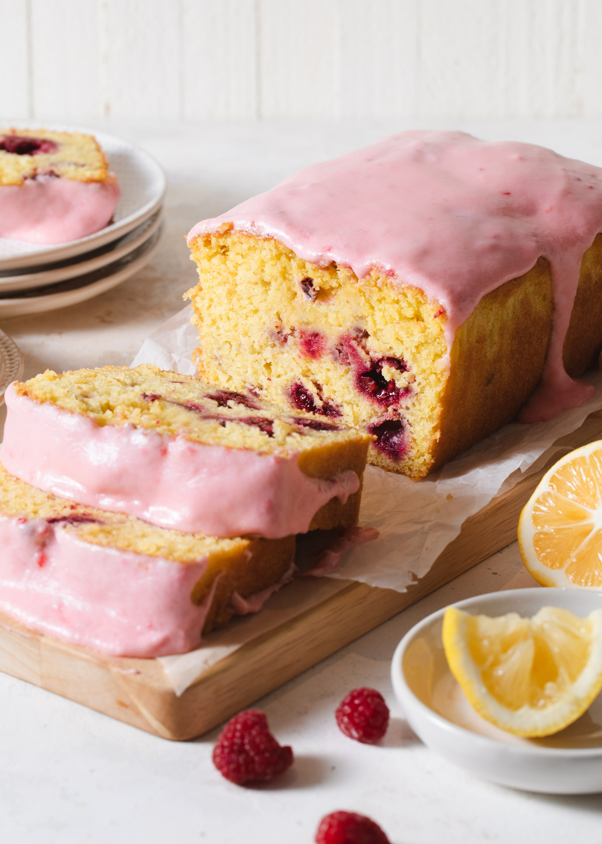 A sliced raspberry lemon loaf cake with pink glaze on top