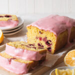 A sliced raspberry lemon loaf cake with pink icing on top