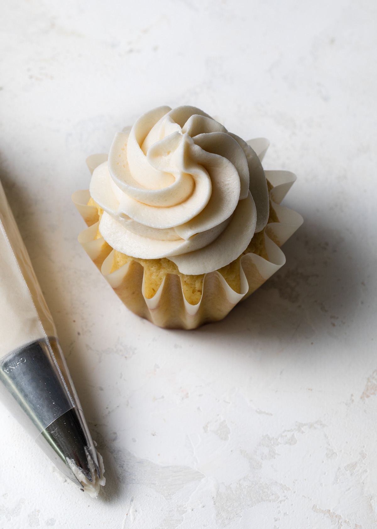 A perfectly piped cupcake with vanilla frosting