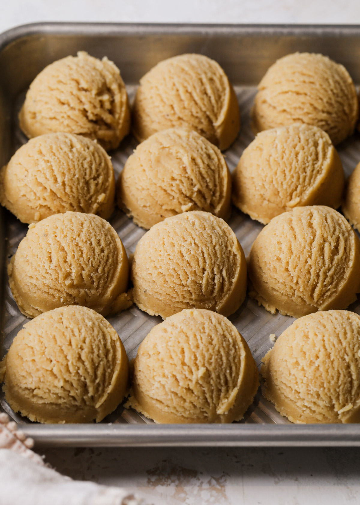 A tray full of unbaked cookie dough balls