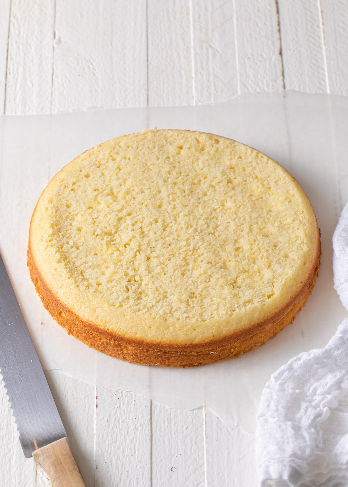 A plain yellow cake layer that has been trimmed flat
