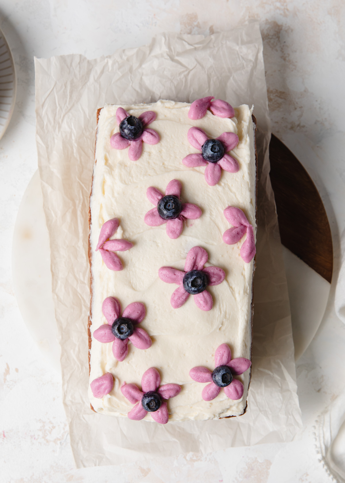 purple buttercream flowers on top of a loaf cake