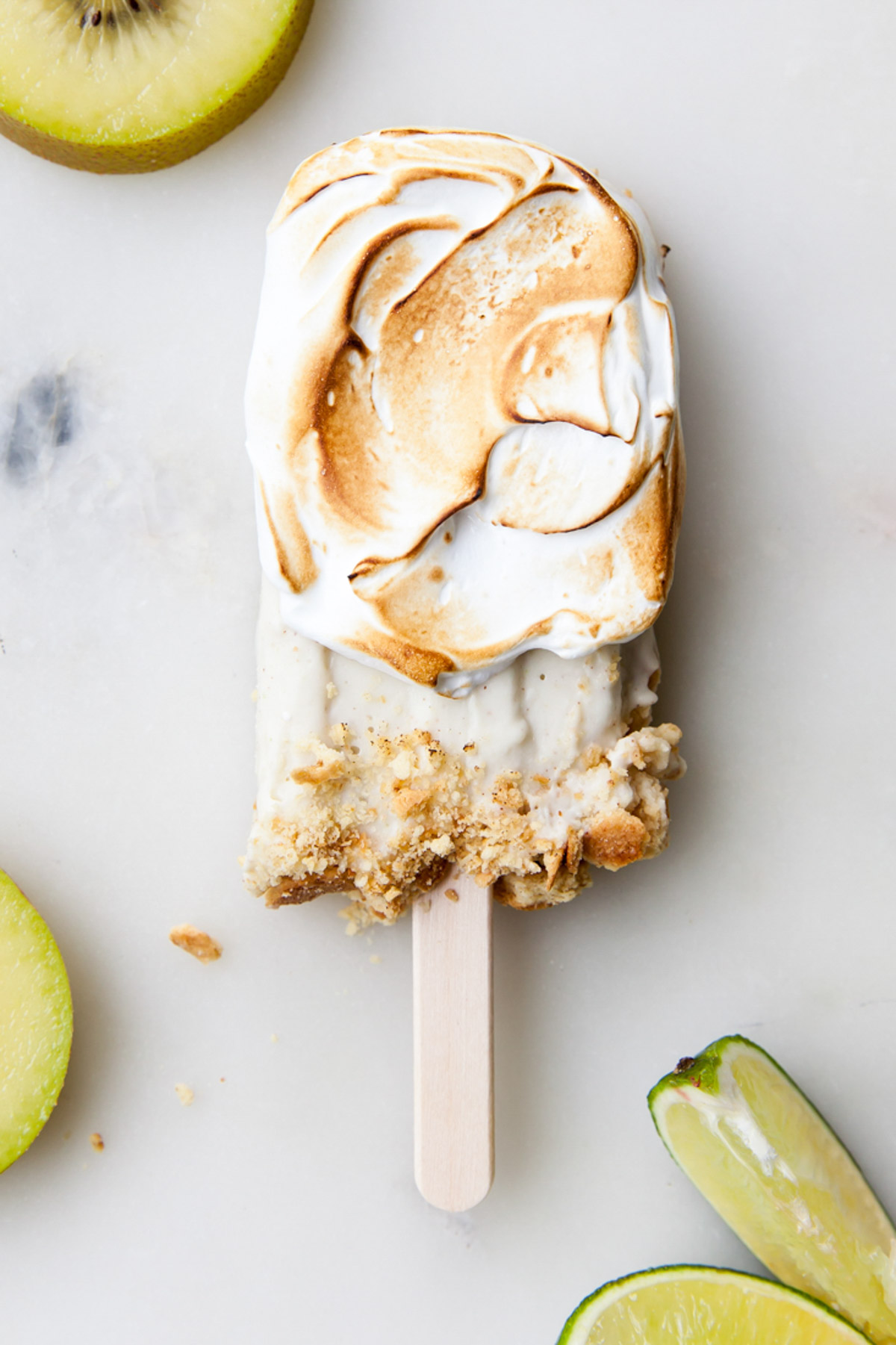 A Kiwi limi popsicle with toasted meringue on the outside.