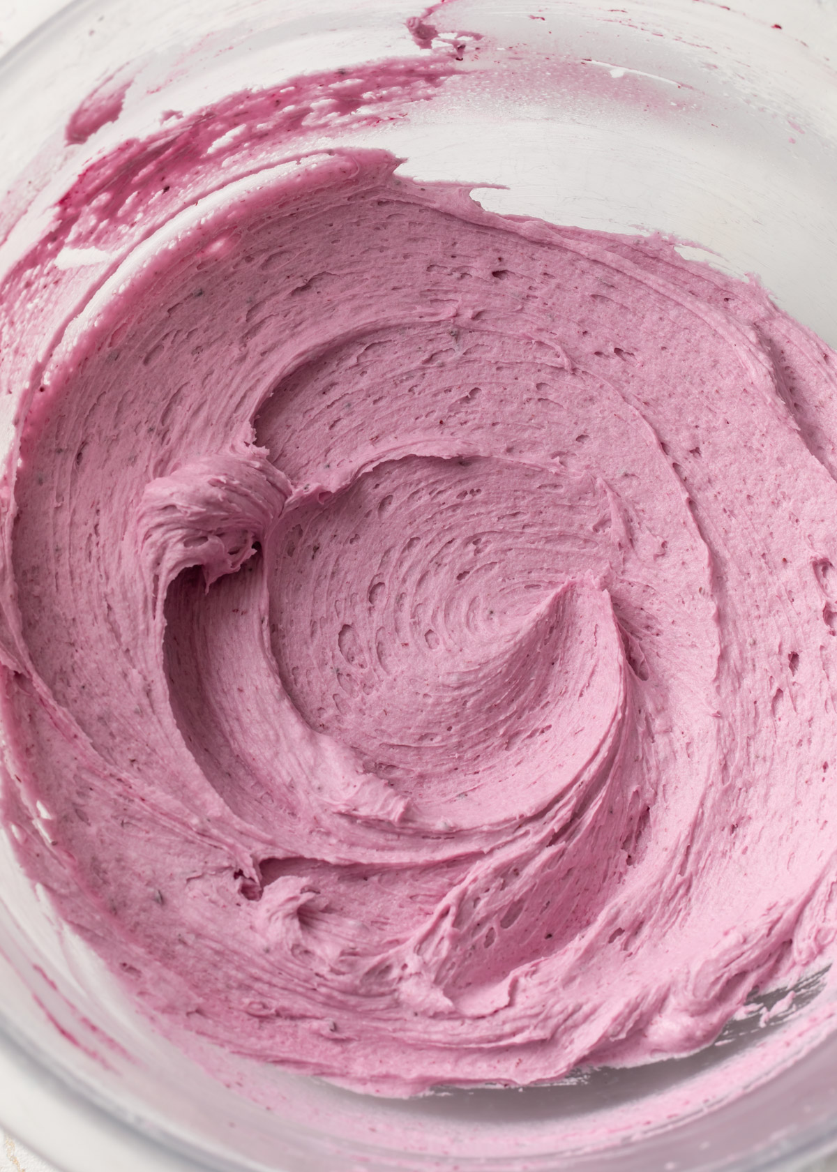 A bowl of bright, fluffy blueberry buttercream frosting