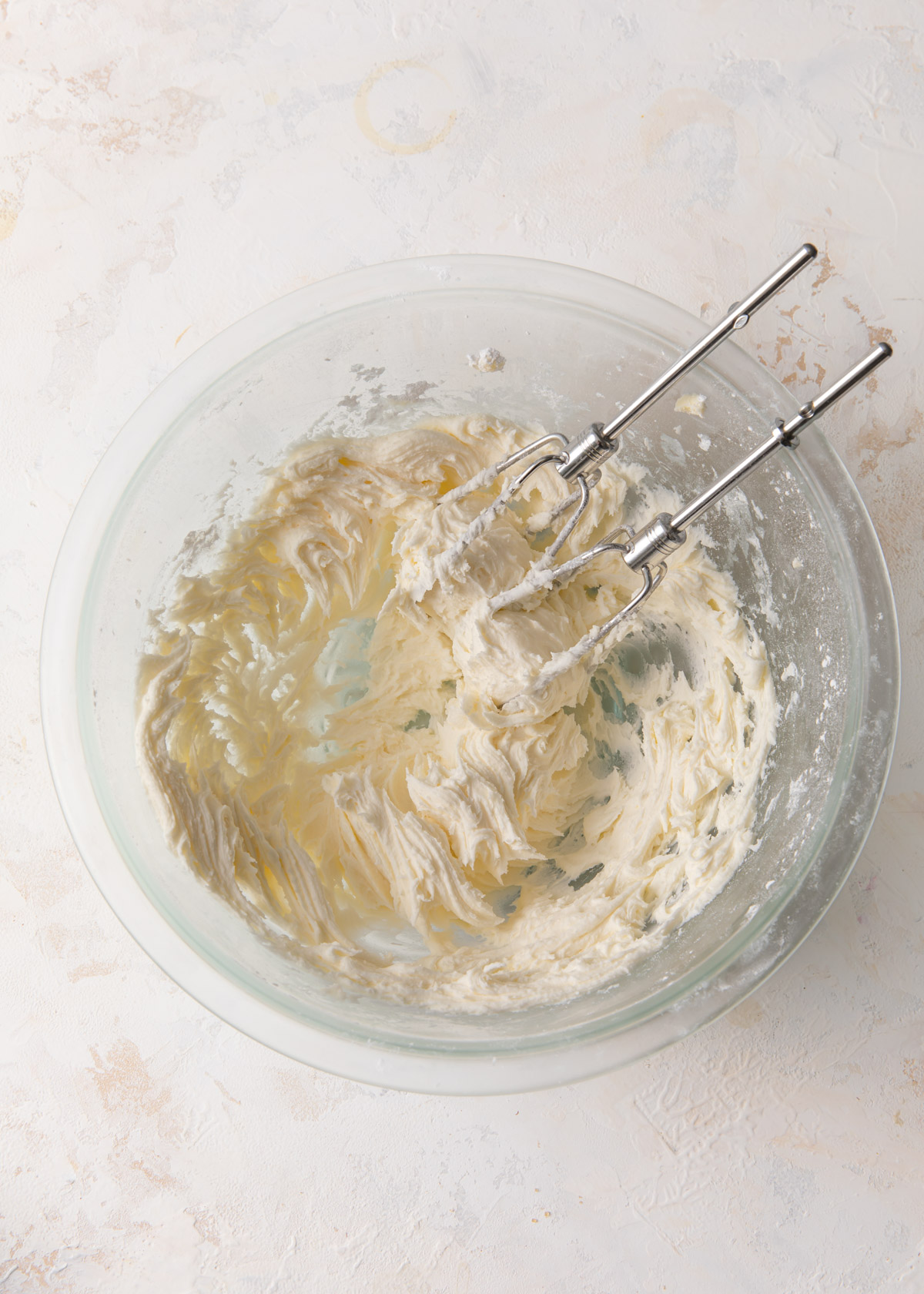 A glass bowl with whipped butter and powdered sugar inside