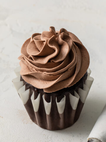 A single chocolate cupcakes with chocolate whipped cream swirled on top