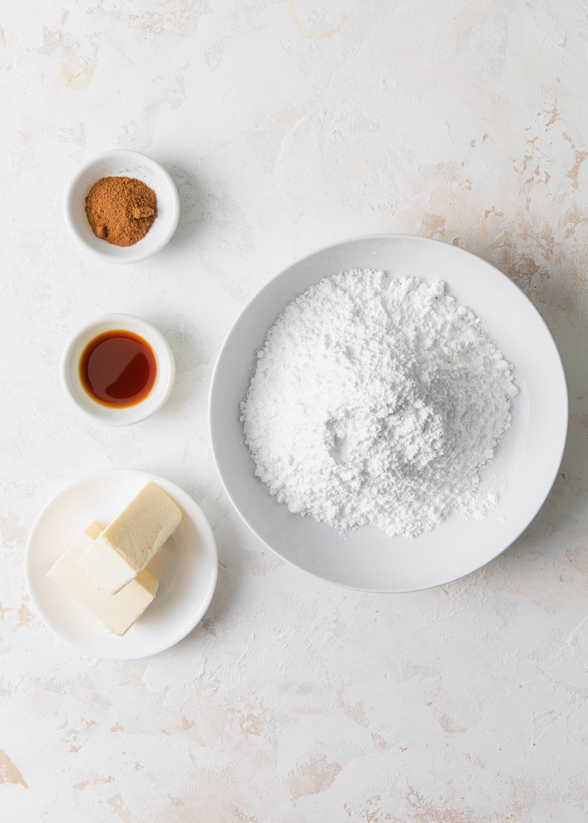 The ingredients for coffee buttercream set out in bowls on a white table