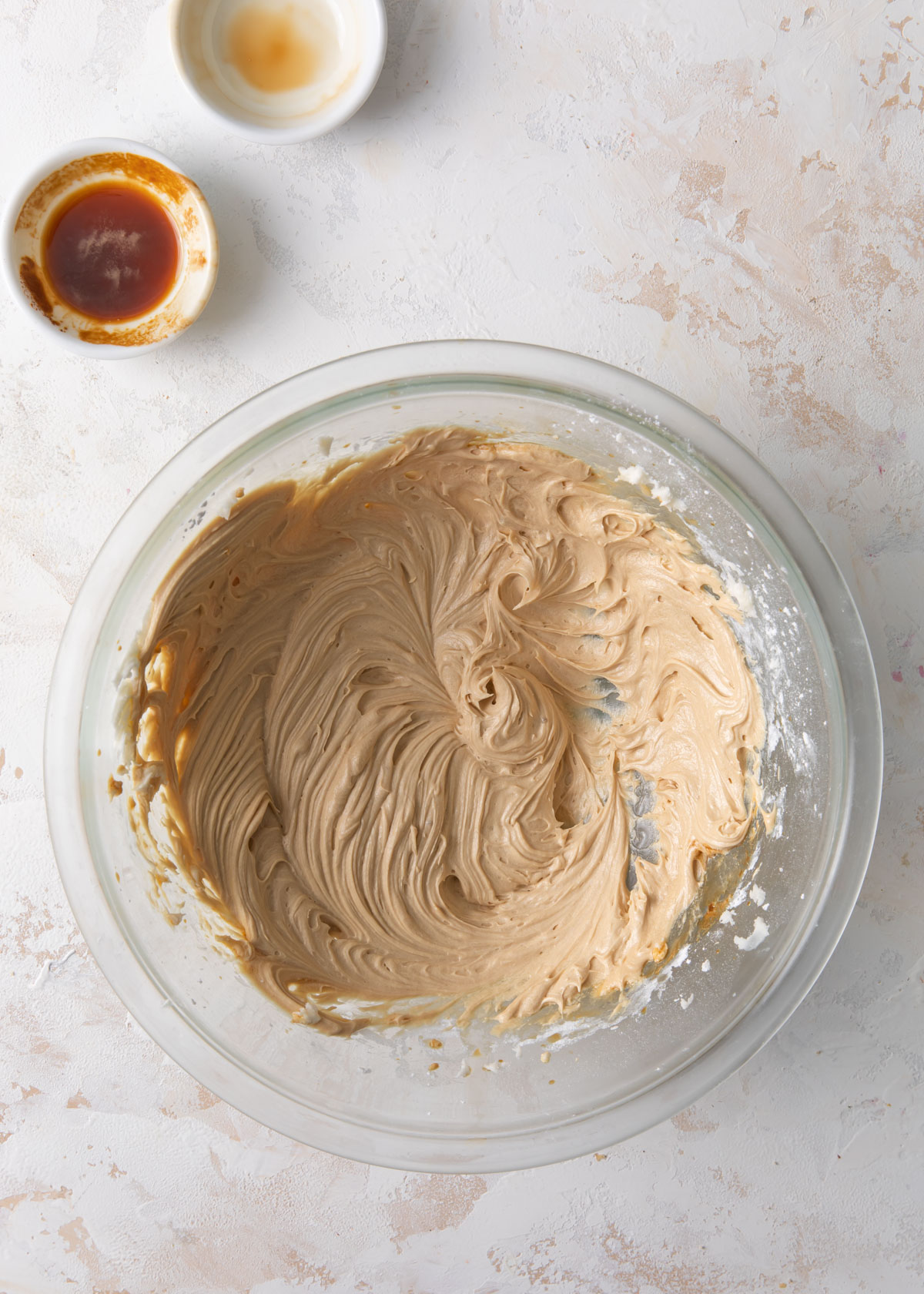 Coffee buttercream mixed together in a glass bowl