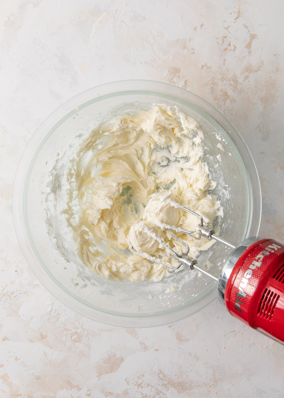 A glass bowl with whipped butter and powdered sugar inside