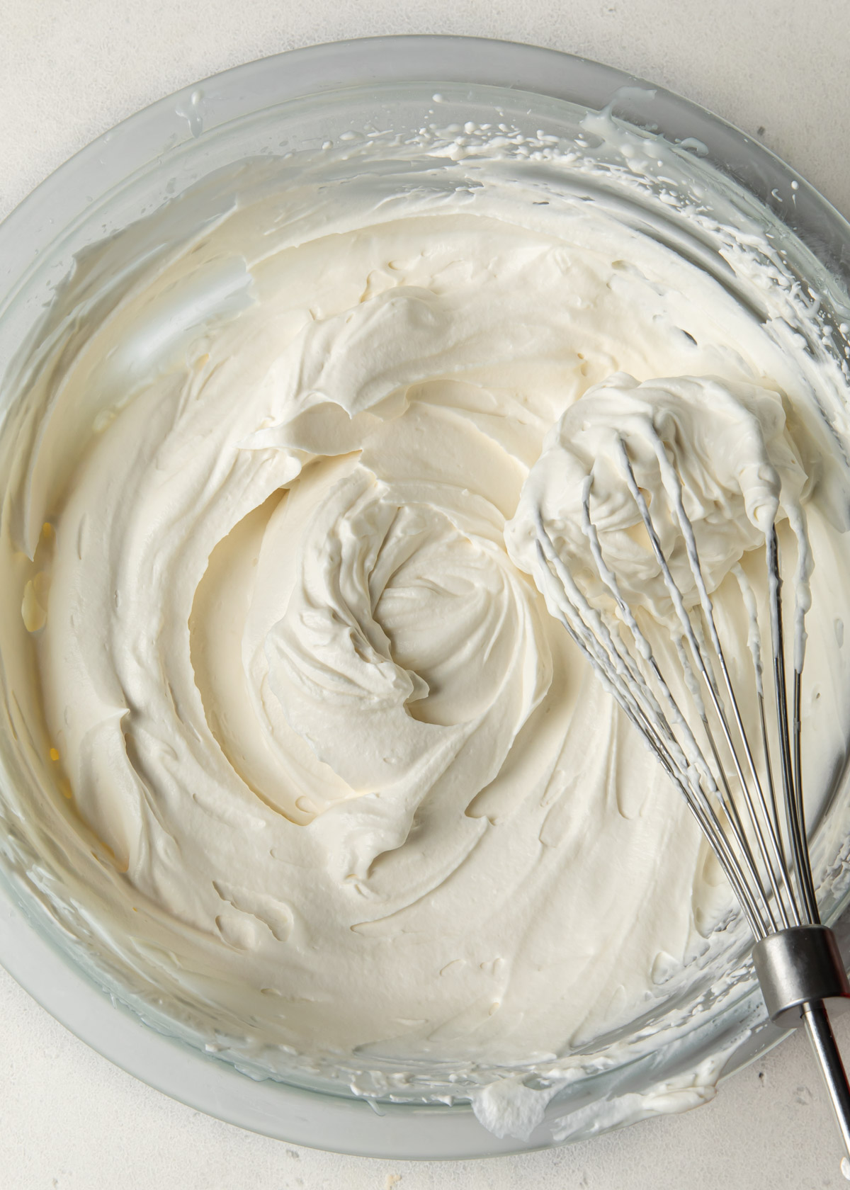A bowl of whipped cream with a whisk