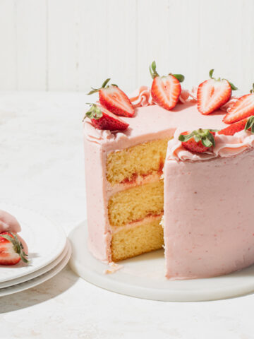 A three layer vanilla cake with strawberry filling that's been sliced open