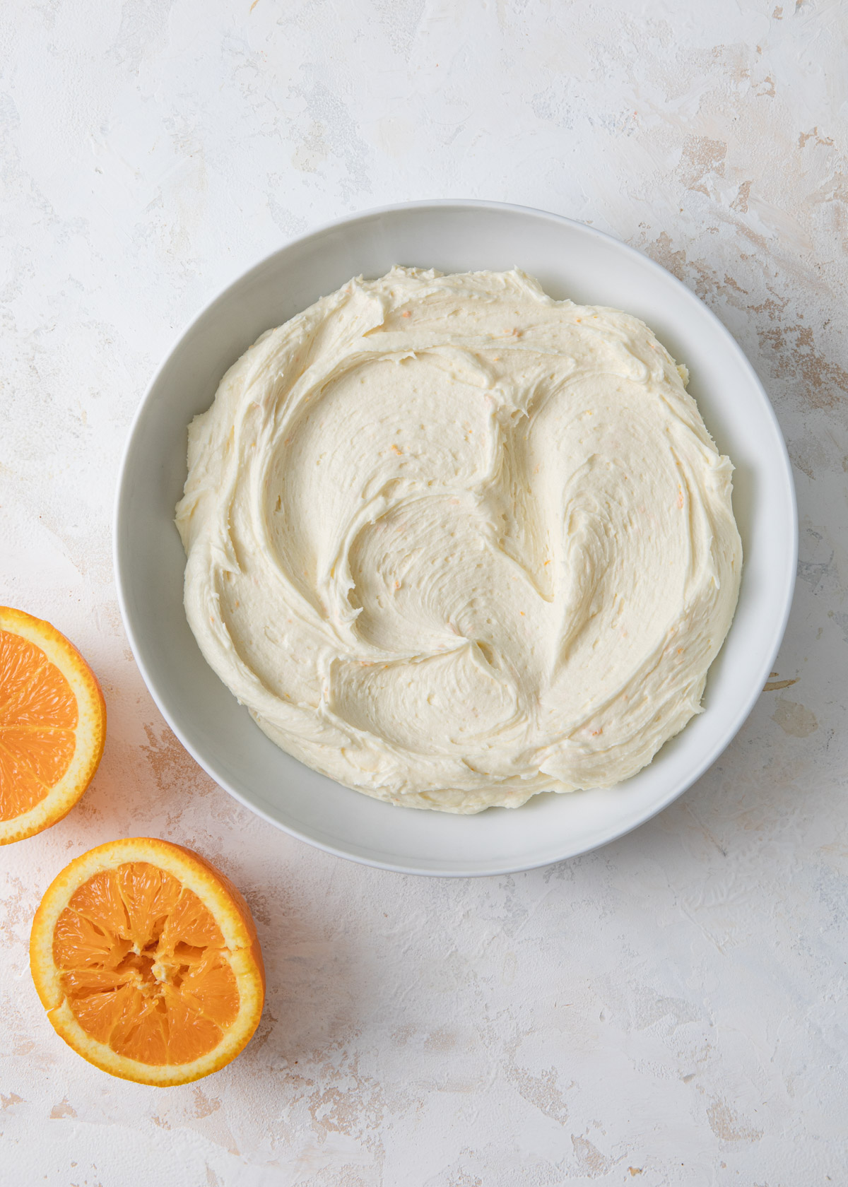 A bowl on fluffy orange buttercream on a white background