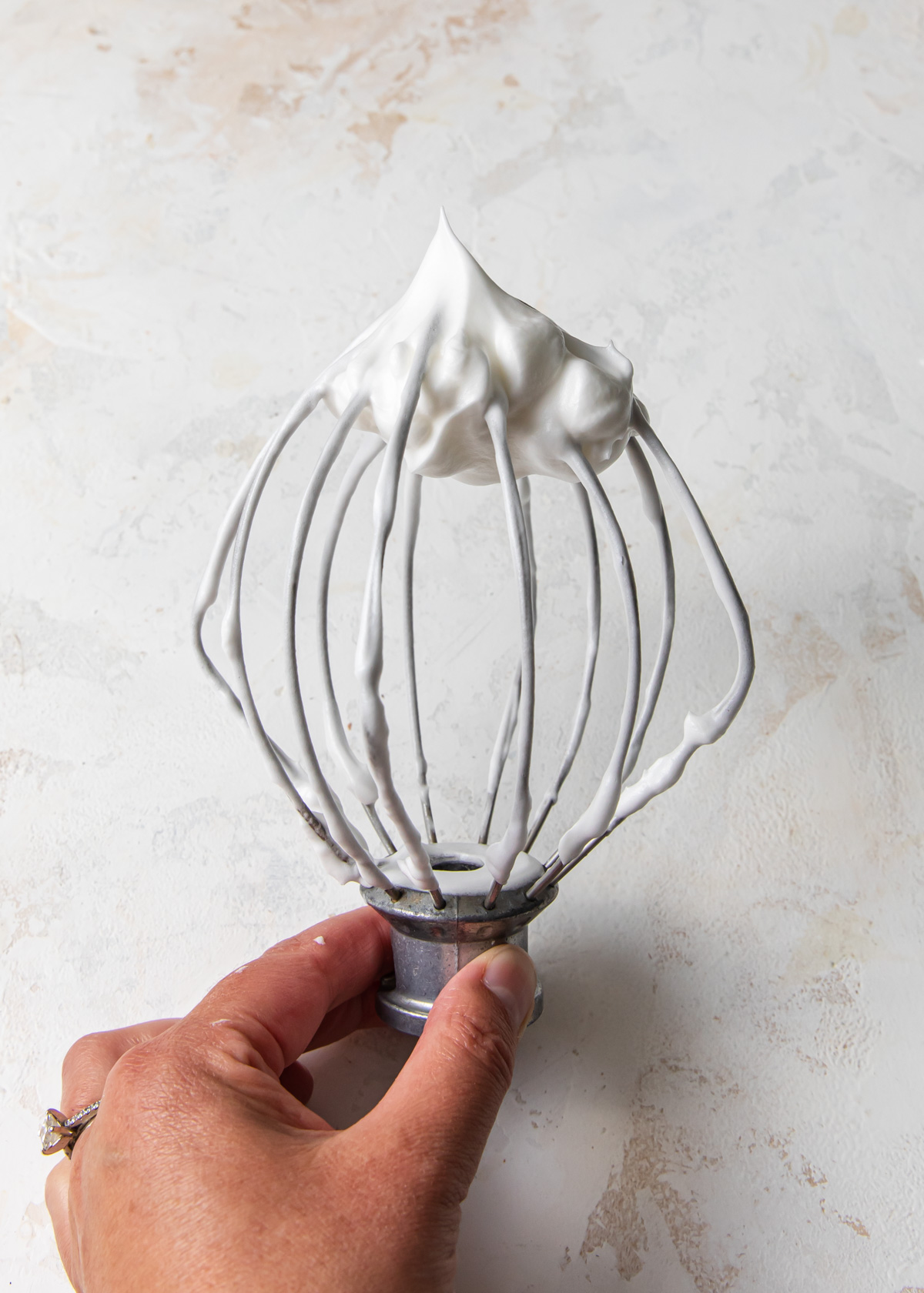 Whipped egg whites on a whisk