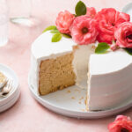 An earl grey chiffon cake that's been sliced with fresh flowers on top