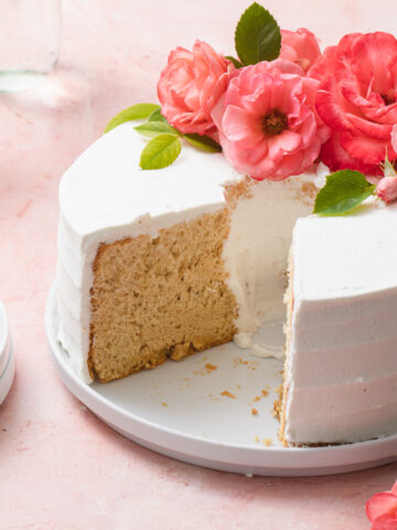 An earl grey chiffon cake that's been sliced with fresh flowers on top