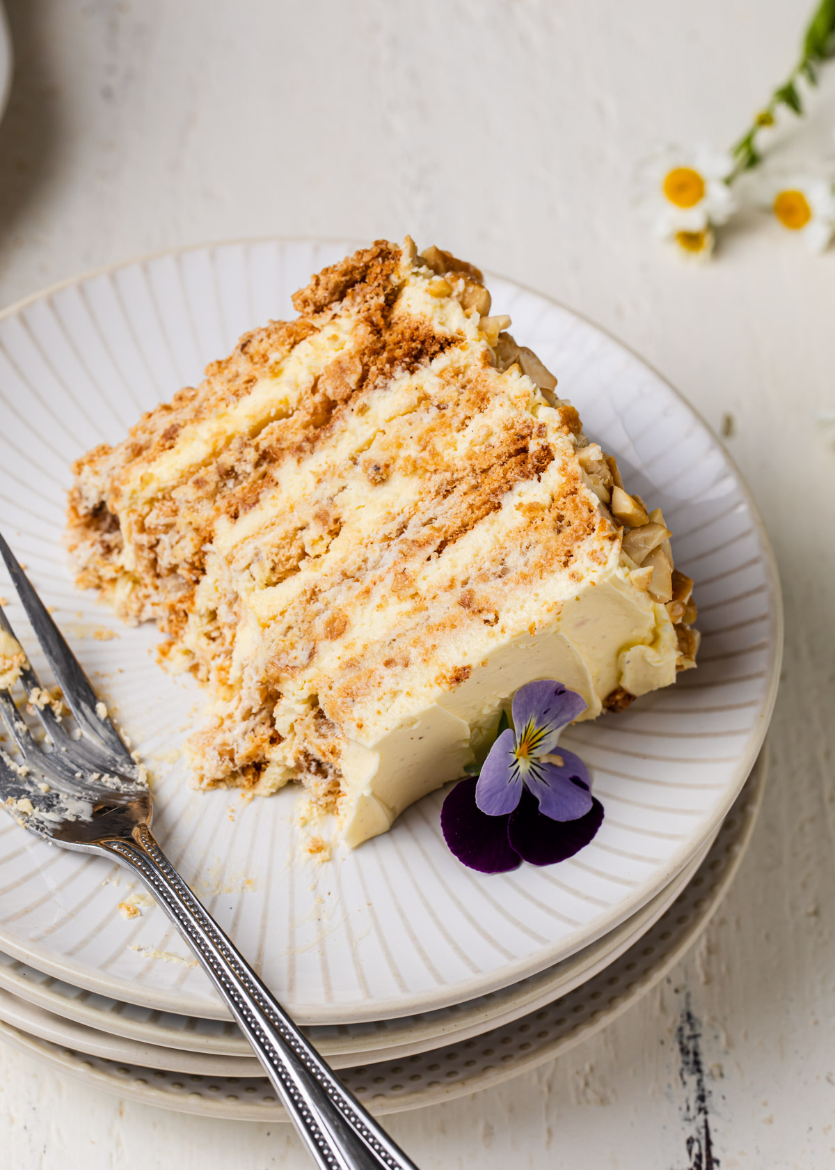 A slice of cashew Sans Rival Cake with layers of French buttercream