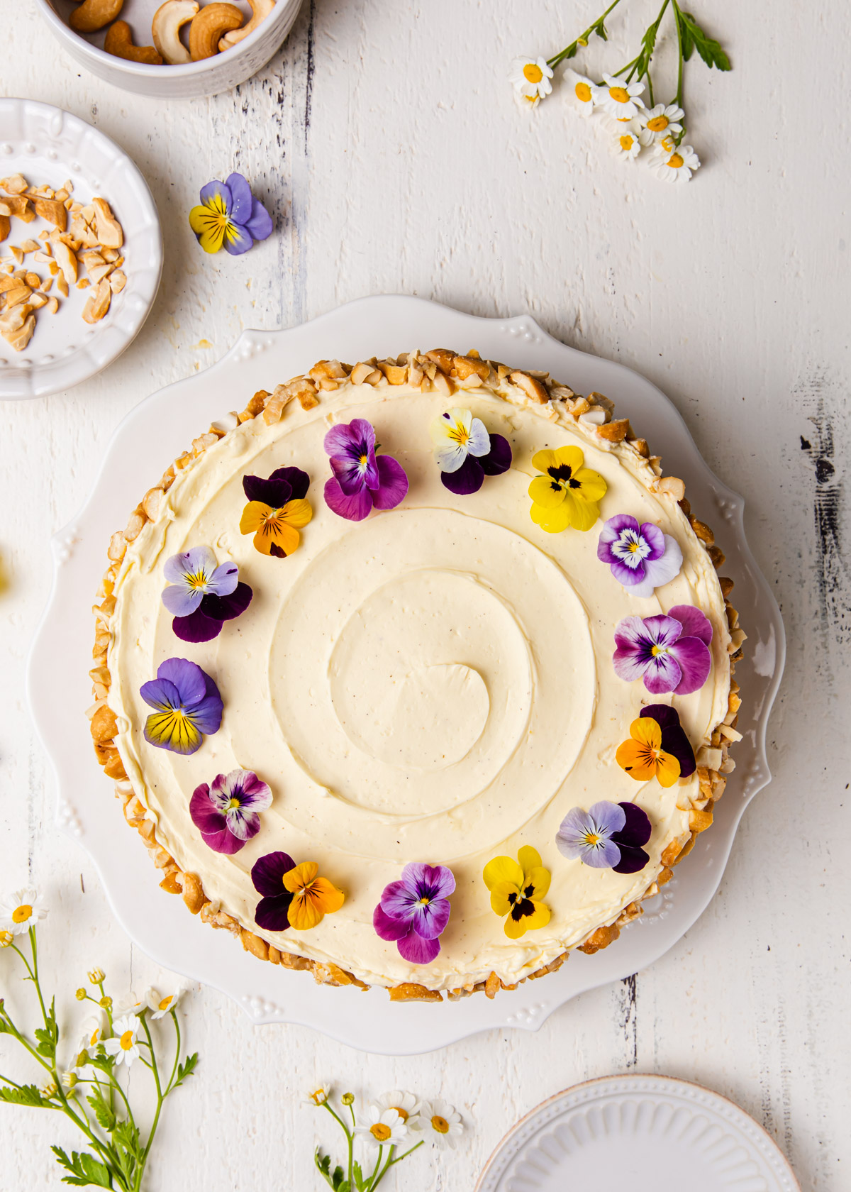 An overhead image of a Filipino Sans Rival Cake with edible flowers on top