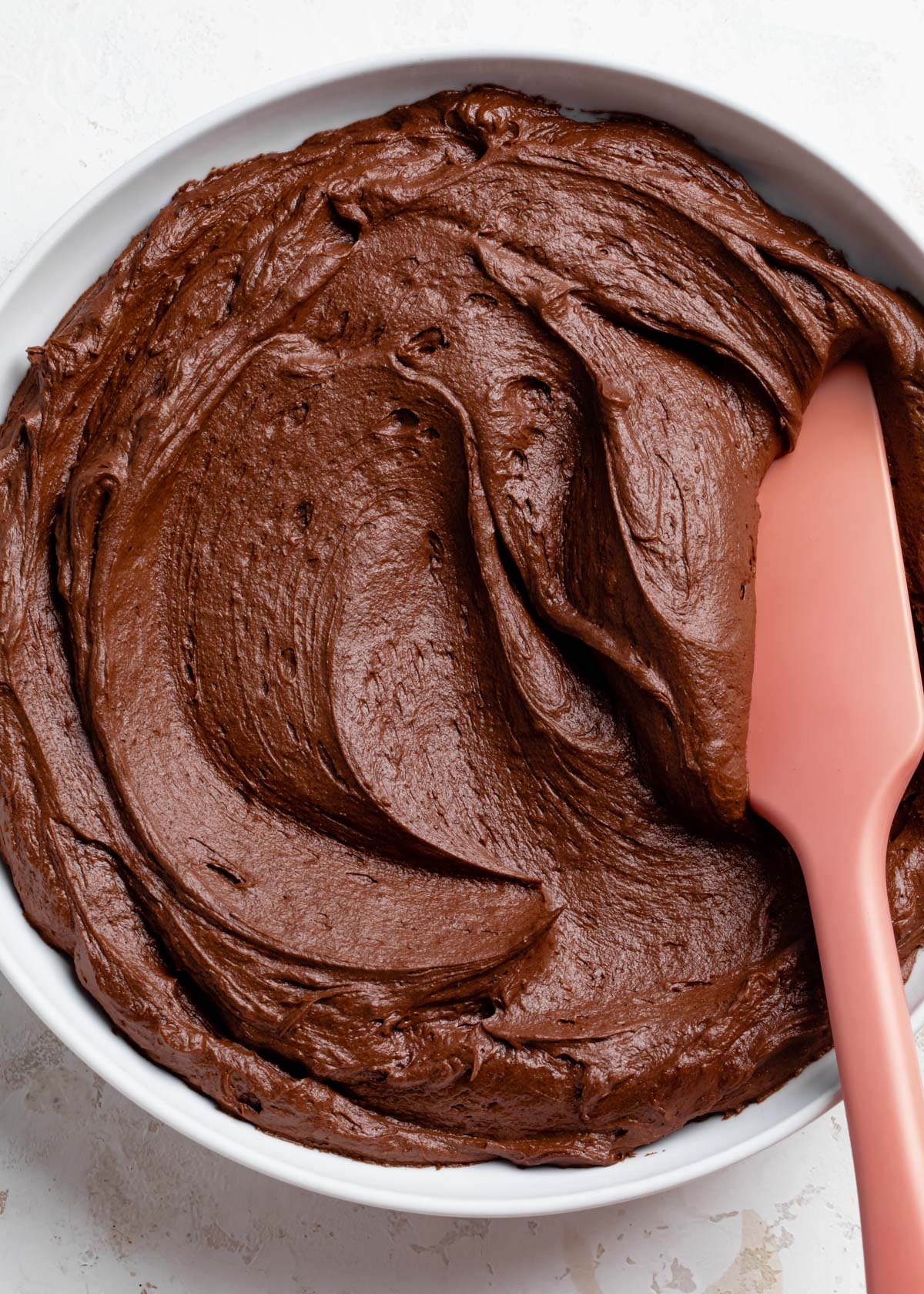 a close-up of creamy chocolate fudge frosting in a bowl