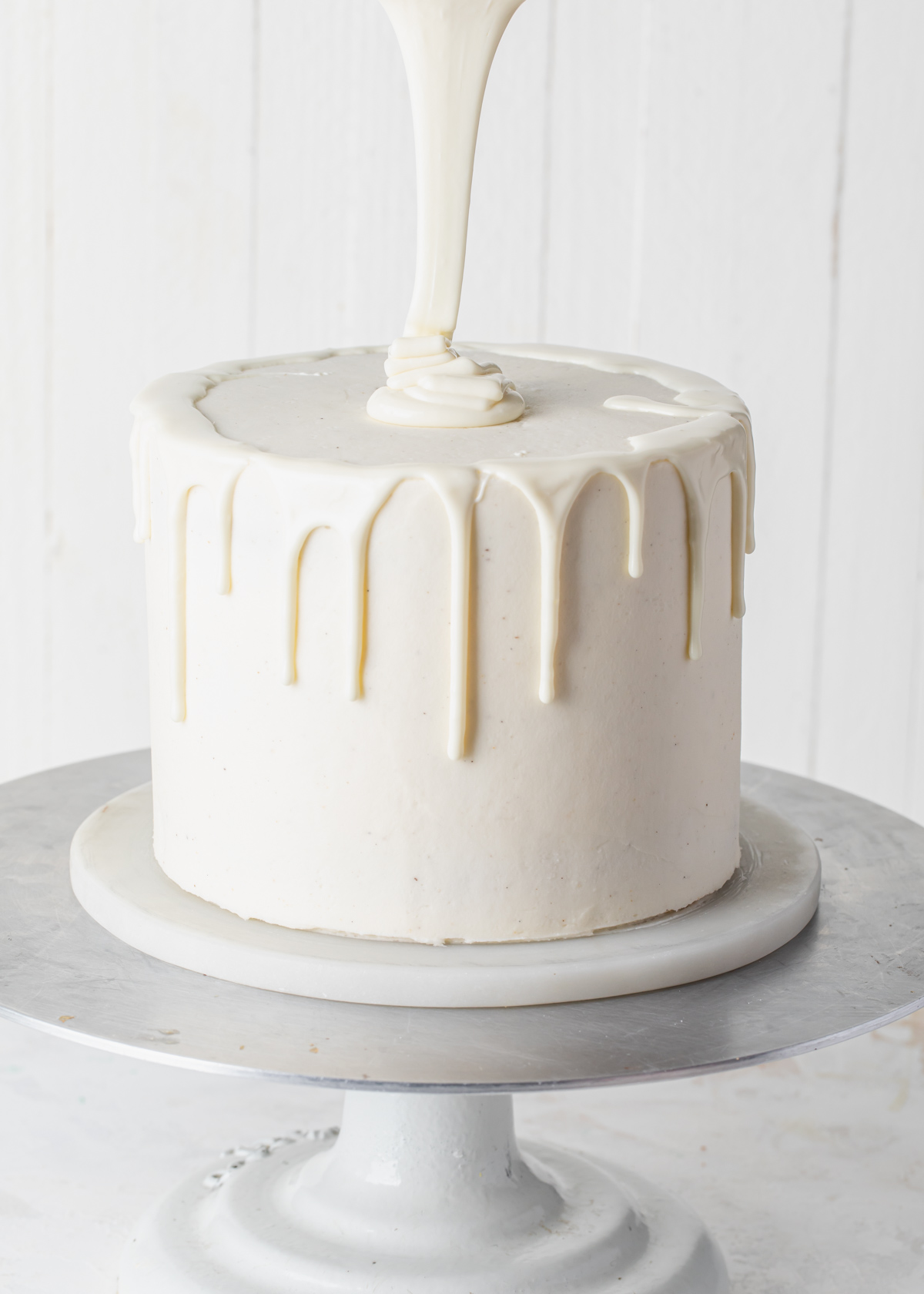 Pour white chocolate ganache on top of a drip cake