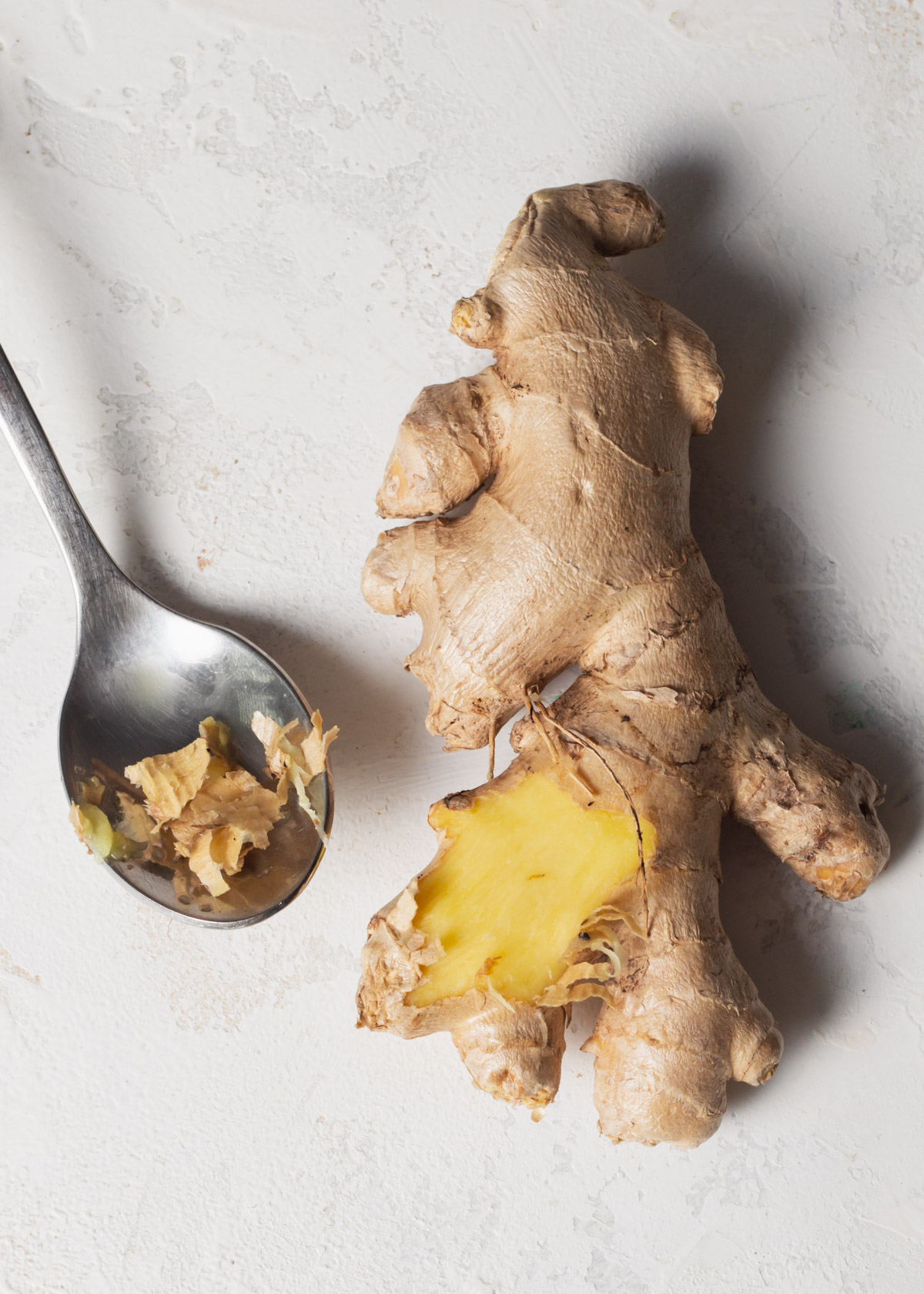 Pealing fresh ginger with a spoon