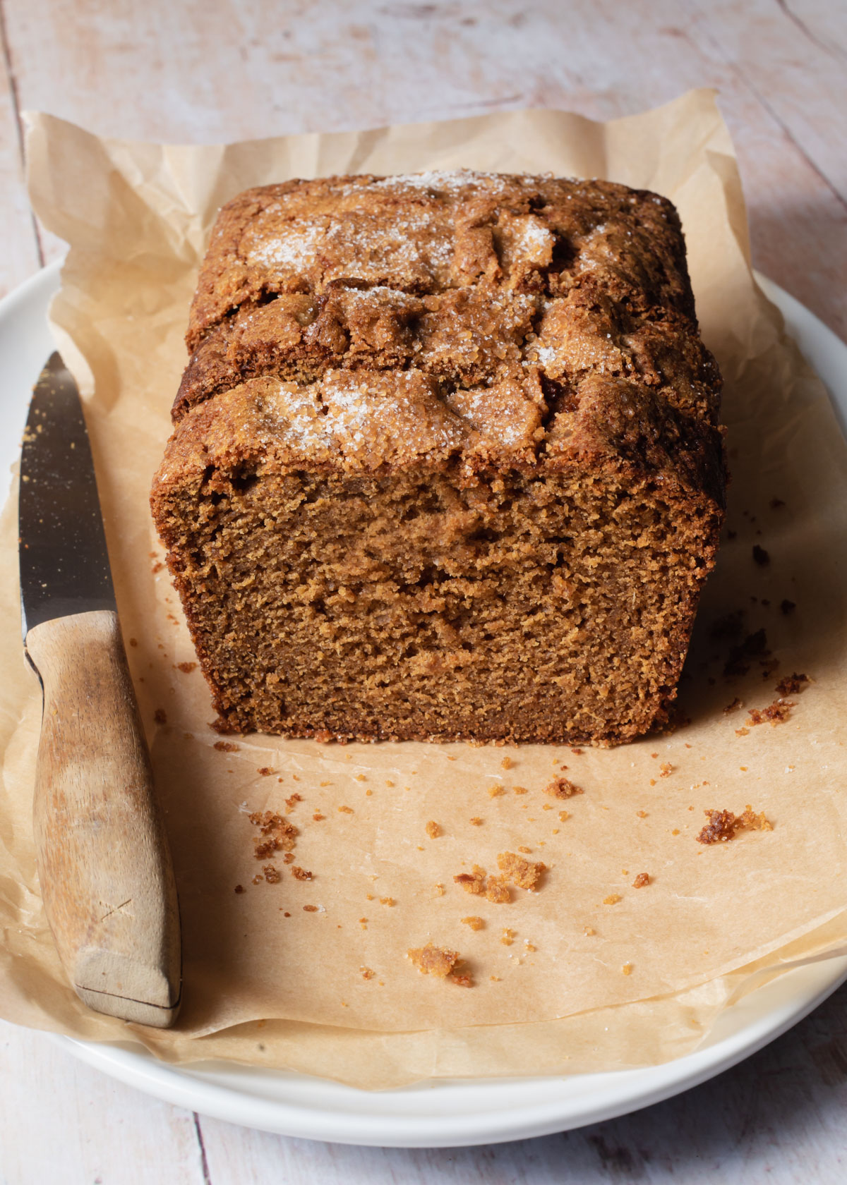 A sliced gingerbread loaf cake sitting on parchment papper