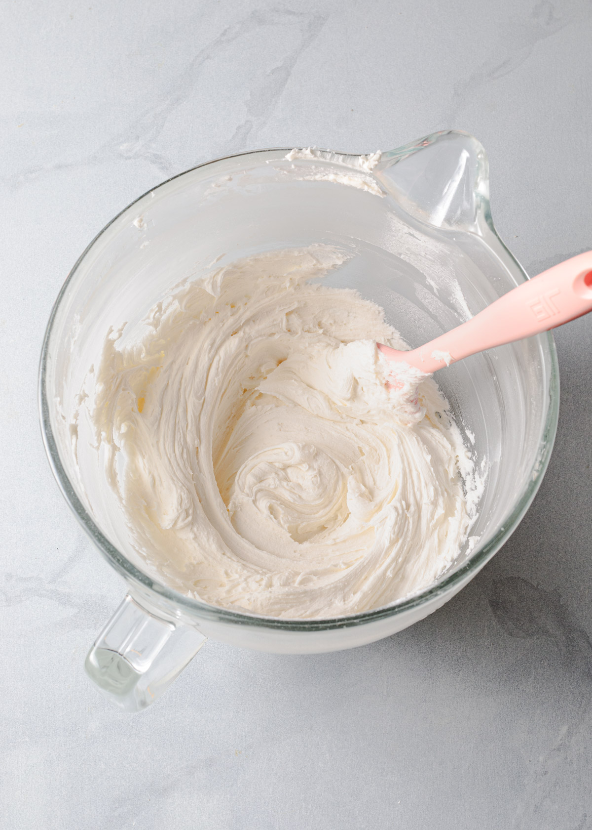 Whipped peppermint frosting in a glass mixing bowl