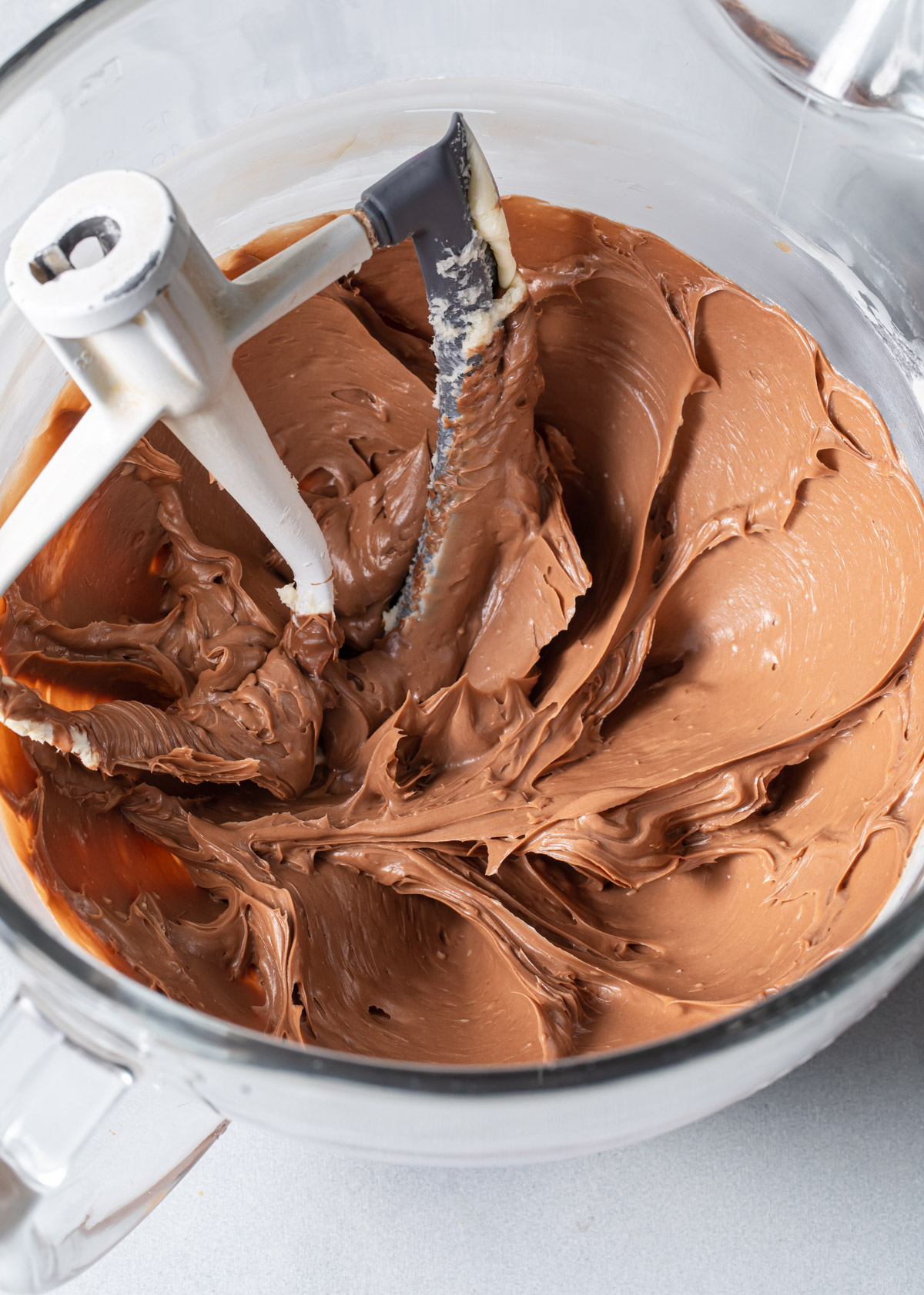 A close up of silky Nutella buttercream in a mixing bowl