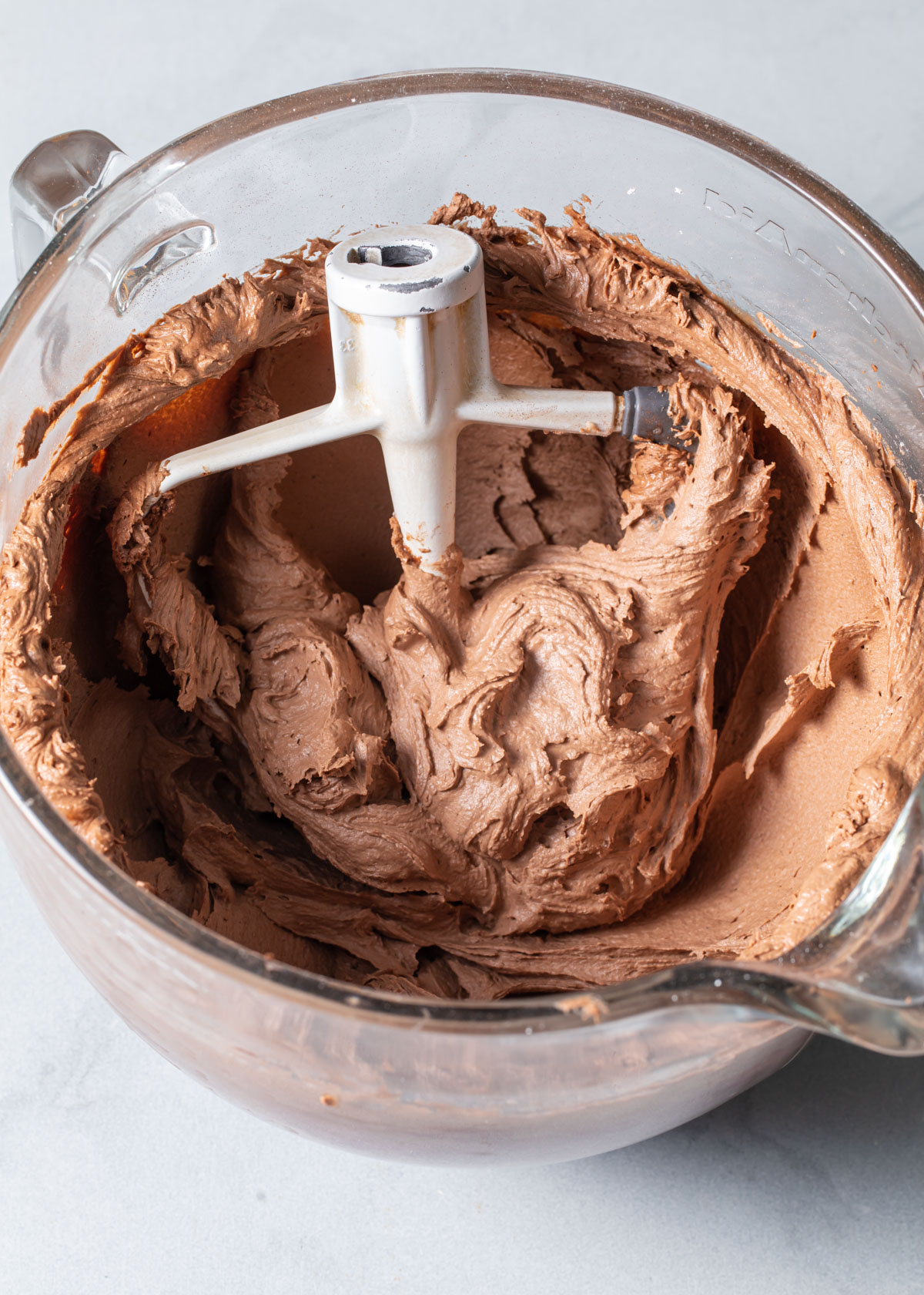 Whipped Nutella buttercream in a glass mixing bowl.