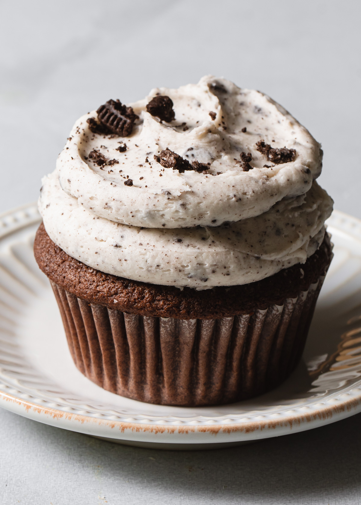 A chocolate cupcake with chocolate cookie frosting on top