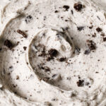 A close-up of a bowl of Oreo buttercream with crushed cookies on top