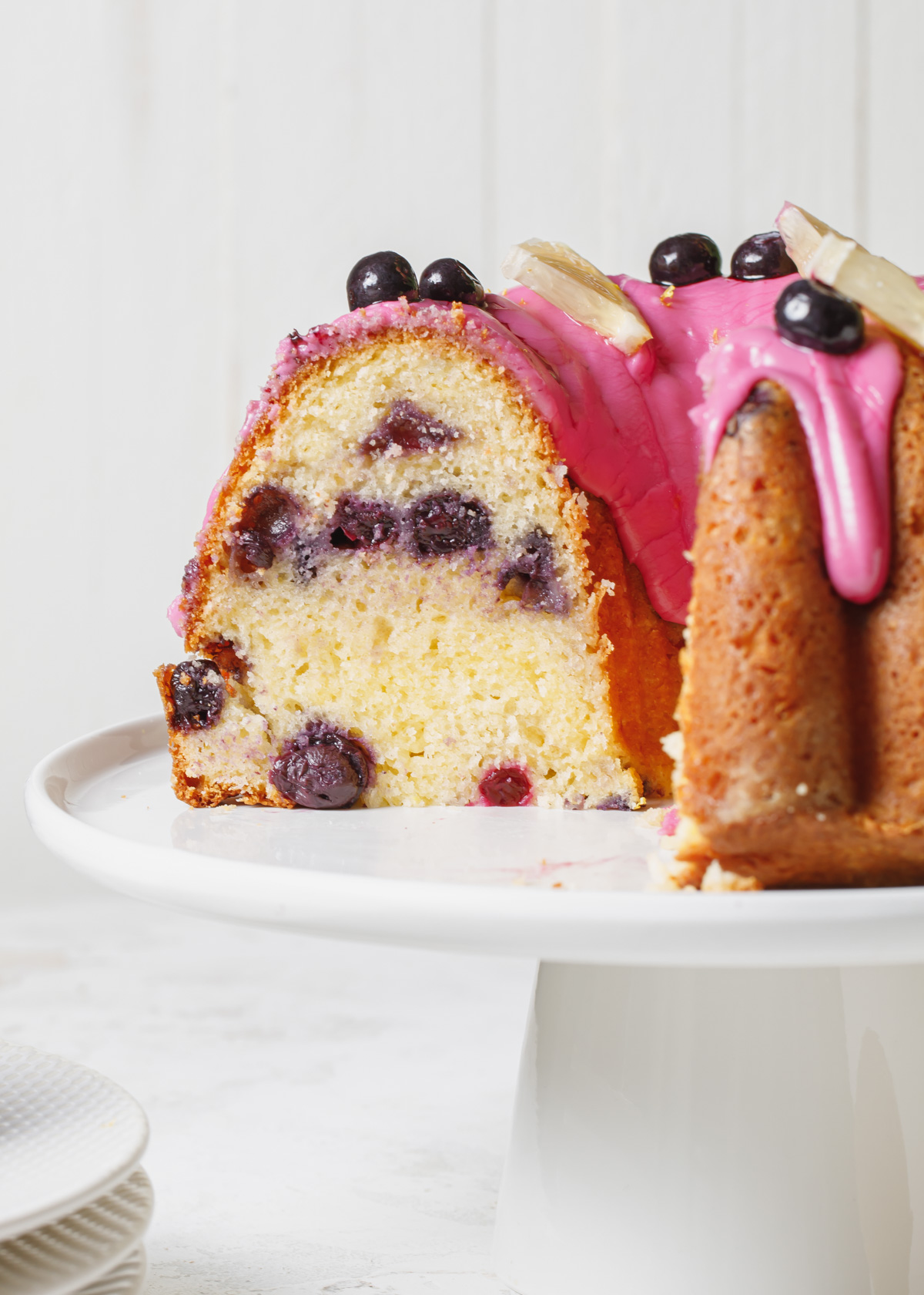 A sliced open lemon blueberry pound cake with blueberry icing